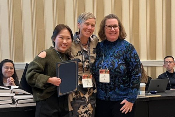 Jessica Ryu and Shelly Hovick posing for picture with top paper award at NCA 2023.