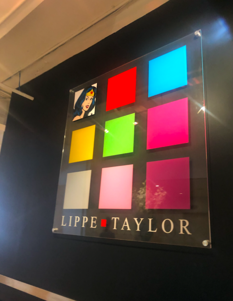 Lippe Taylor's logo hanging on a wall in their office