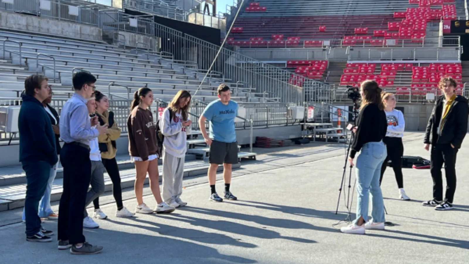 Students in Ohio Stadium gathered around a tripod on the sideline.
