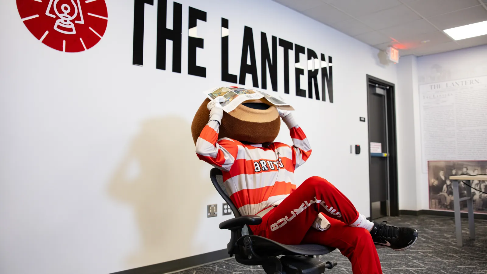 Brutus holding newspaper over his face 