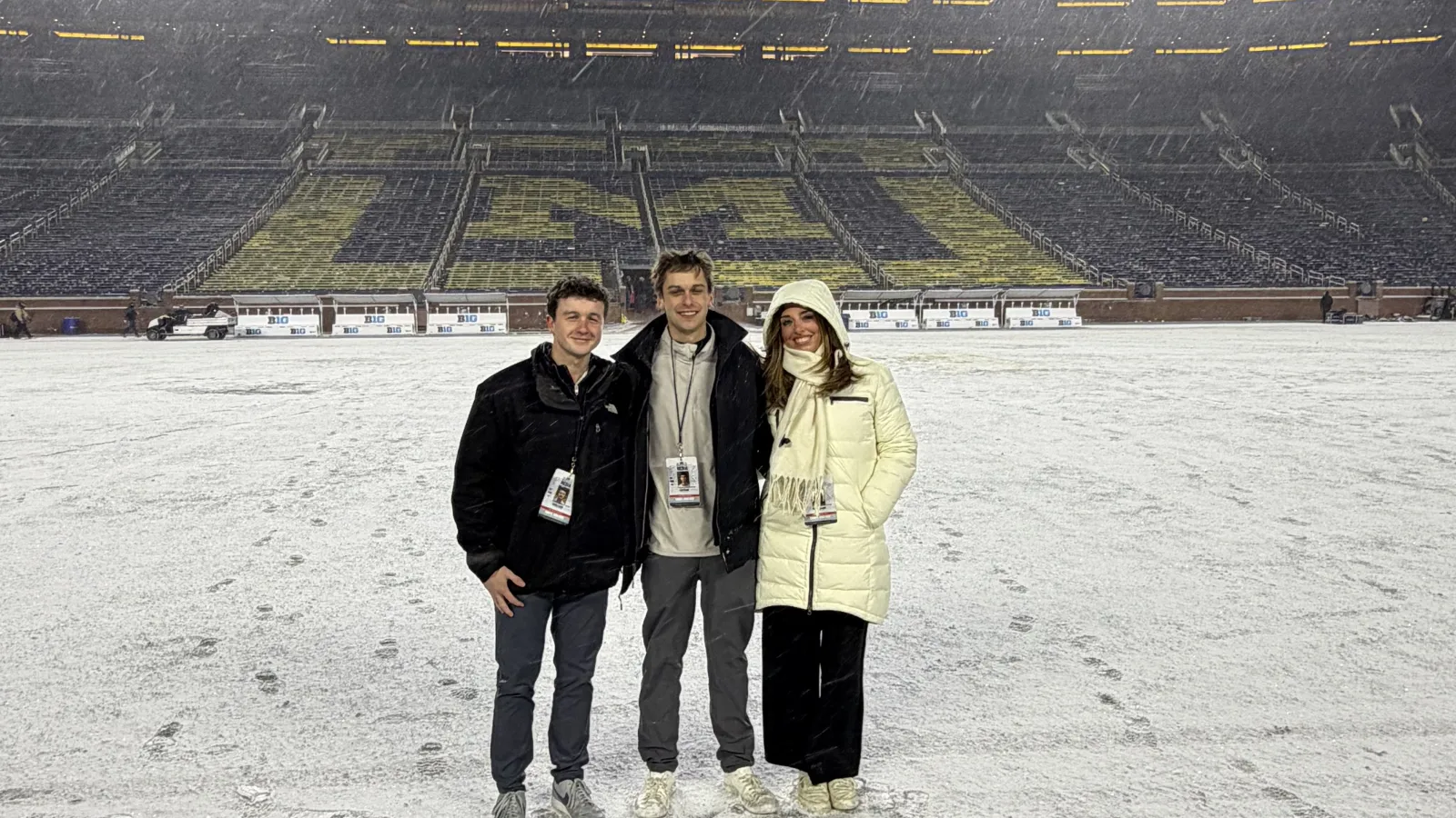 Undergraduate students pose on the field at Michigan Stadium 