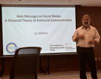 Presenter giving a talk on hate messages on social media