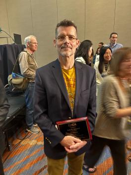 Scott Campbell holding his ICA Fellow award