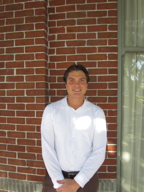 Randolph standing in front of brick wall