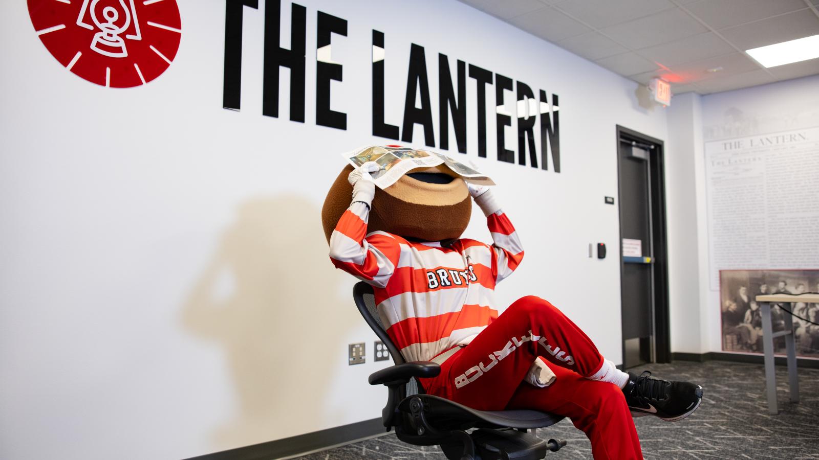 Brutus holding newspaper over his face 