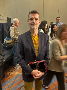Scott Campbell holding his ICA Fellow award